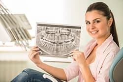 Прорезывание зубов мудрости может спровоцировать искривление рядом стоящих зубов.