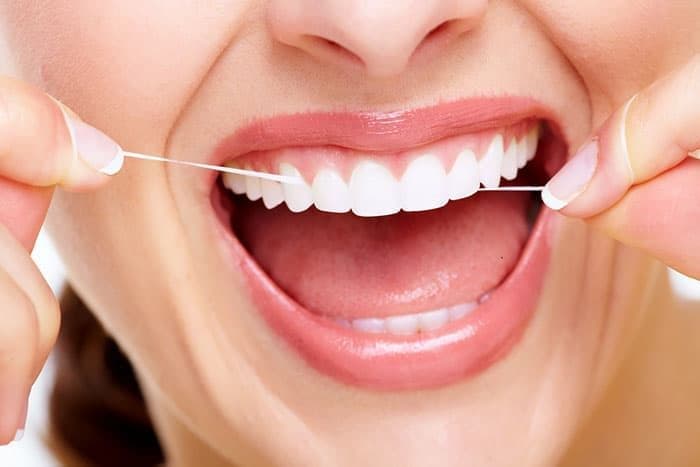 Чистка зубов при помощи зубной нити